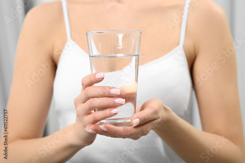 Healthy habit. Closeup of woman holding glass with fresh water indoors