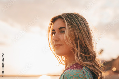Portrait of one young woman at the beach looking at the sea enjoying free time and freedom outdoors. Having fun relaxing and living happy moments.. #611526967