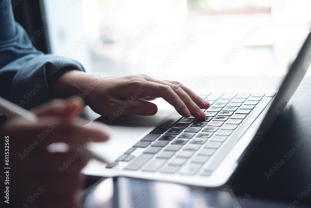 Close up of business woman hands typing on laptop computer and digital tablet, searching and surfing the internet on office desk, online working, telecommuting, freelancer at work concept Close up of business woman hands typing on laptop computer and digital tablet, searching and surfing the internet on office desk, online working, telecommuting, freelancer at work concept