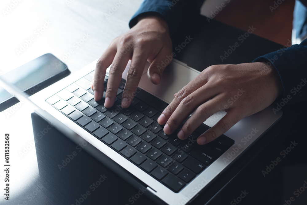 Business man hands typing on laptop computer keyboard, searching information, surfing the internet on dark office desk, distance job, online working, business and technology concept Business man hands typing on laptop computer keyboard, searching information, surfing the internet on dark office desk, distance job, online working, business and technology concept