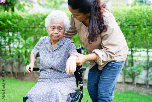 Caregiver help Asian elderly woman disability patient sitting on wheelchair in park, medical concept. © manassanant