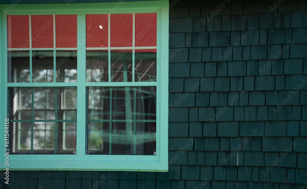 antique green wooden window frame on black shingled wall off set window glass reflecting red roof square window rectangular window panes room for type empty framed space side of building symmetry antique green wooden window frame on black shingled wall off set window glass reflecting red roof square window rectangular window panes room for type empty framed space side of building symmetry