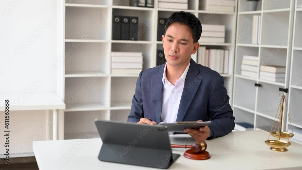 Asian female lawyer chatting online with client on laptop, smartphone discussing details of lawsuit. in office. Asian female lawyer chatting online with client on laptop, smartphone discussing details of lawsuit. in office.