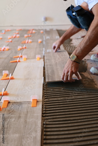 Pose de carrelage au sol par un artisan dans une maison