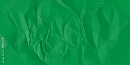 Crumpled green paper texture. Sheet of crumpled green paper as background, top view. The green paper background is wrinkled, creating a rough texture with light and shadow.