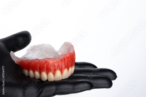 Waxed upper denture base on woman hand. Test base with artificial teeth ready to acrylization.