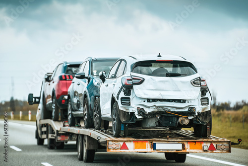 Tow truck with a broken car on a country road. Tow truck transporting car on the highway. Car service transportation concept. Roadside Rescue.