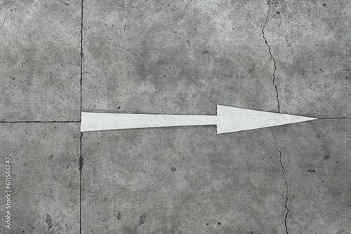 Traffic direction painted on the concrete road. Straight forward arrow.