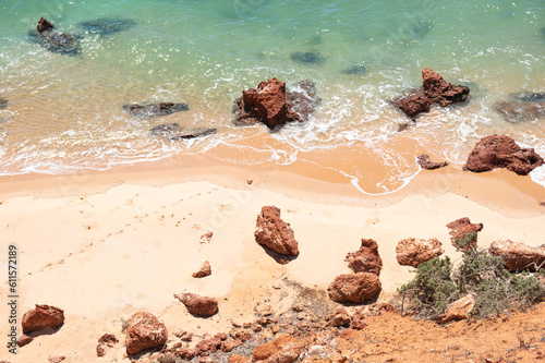 Ocean sandy beach with rocks and turquoise water. Top View