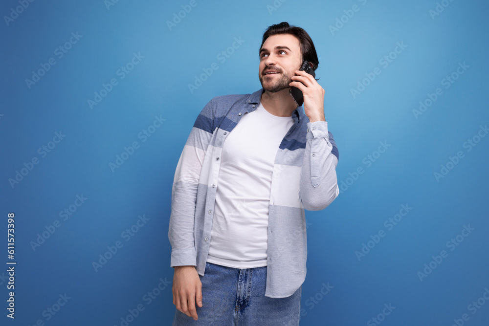 nice brunette guy in casual style chatting on the phone nice brunette guy in casual style chatting on the phone