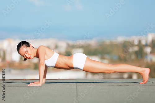 Fitness, woman and portrait in push ups on roof top for exercise, workout or training for healthy body in city. Happy, fit and active female in yoga, stretching or exercising arms on floor in town