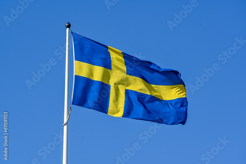 Swedish flag on flag pole and clear blue sky