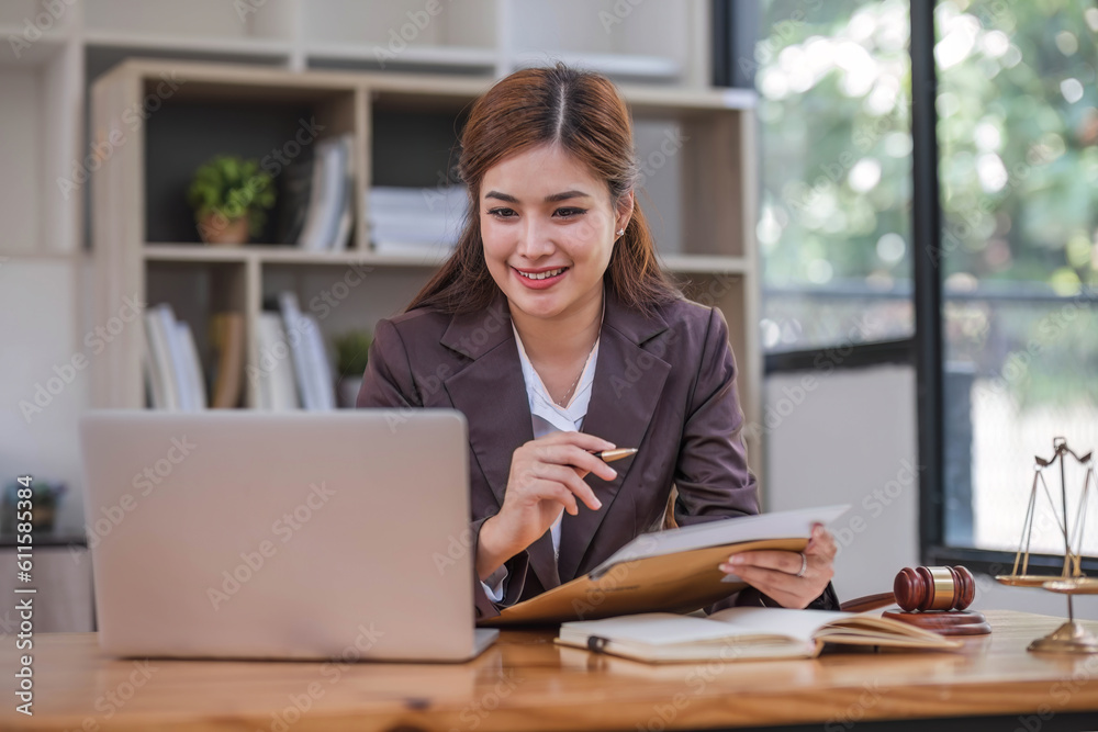 Looking camera. Young Attractive Asian female lawyer working in office with contract and law books when sitting at desk. Law, legal services, advice, Justice and real estate concept. Looking camera. Young Attractive Asian female lawyer working in office with contract and law books when sitting at desk. Law, legal services, advice, Justice and real estate concept.