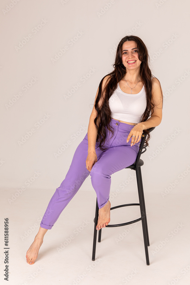 Fashionable young woman posing on chair
