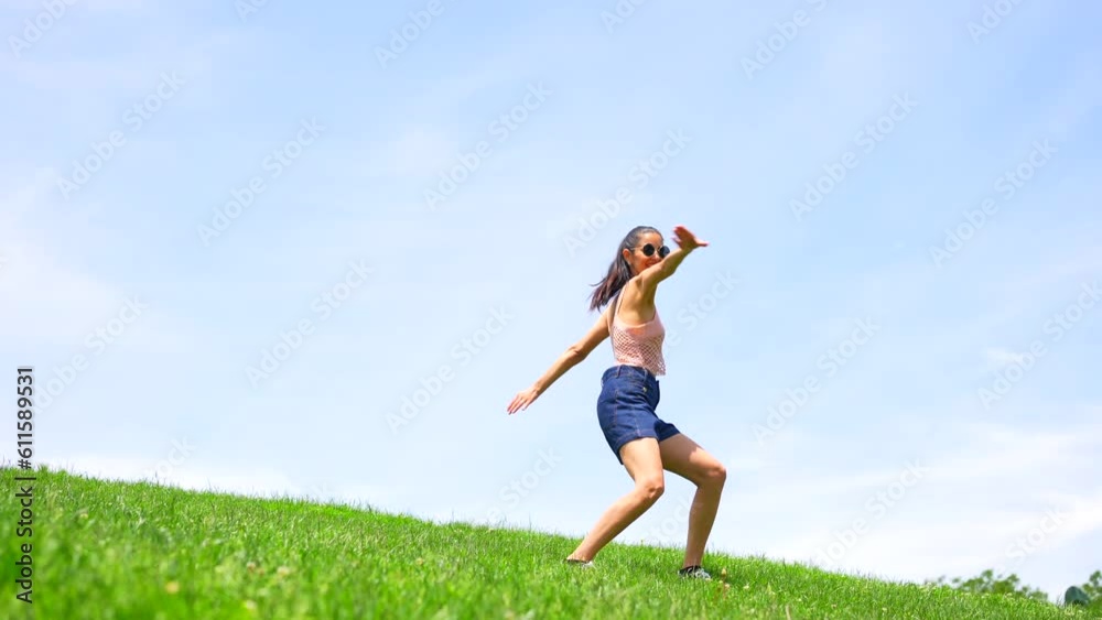 Caucasian brunette woman doing a dance in a park over the sky, smiling doing a handstand Caucasian brunette woman doing a dance in a park over the sky, smiling doing a handstand