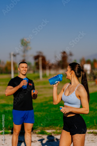 Fototapeta Naklejka Na Ścianę i Meble -  Fitness couple is about to drink some water while having a conversation