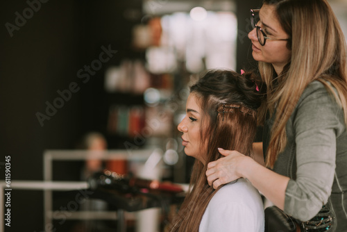 Brunette hair stylist making her client hair 