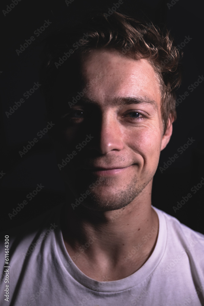 A close up portrait of a man in a dark room.