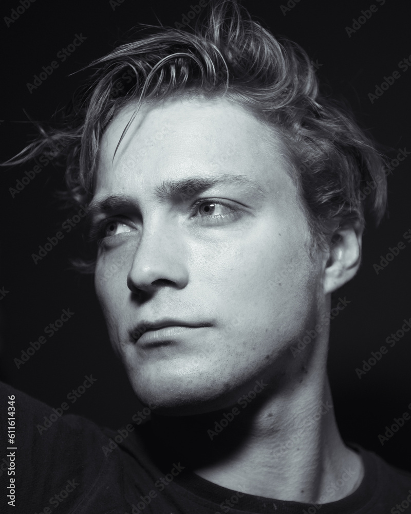 Monochrome shot of a male model in a dark room Monochrome shot of a male model in a dark room