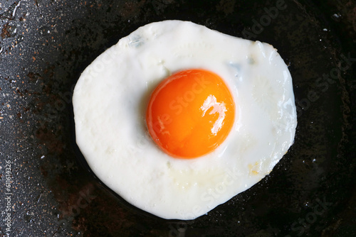 Top view of a sunny side up egg being fried in a pan photo