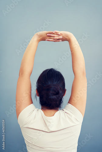 Woman, work and stretching arms on studio, blue background or tired body from working, bad posture or strain. Stretch, arm and hands or businesswoman focus on care of back pain and stress management