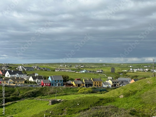 An old Irish village, cast in a landscape with cows photo