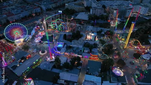 Aerial view fun fair. Twilight time illumination Vienna city famous theme amusement park Prater riverside downtown aerial panorama 4k Austria photo