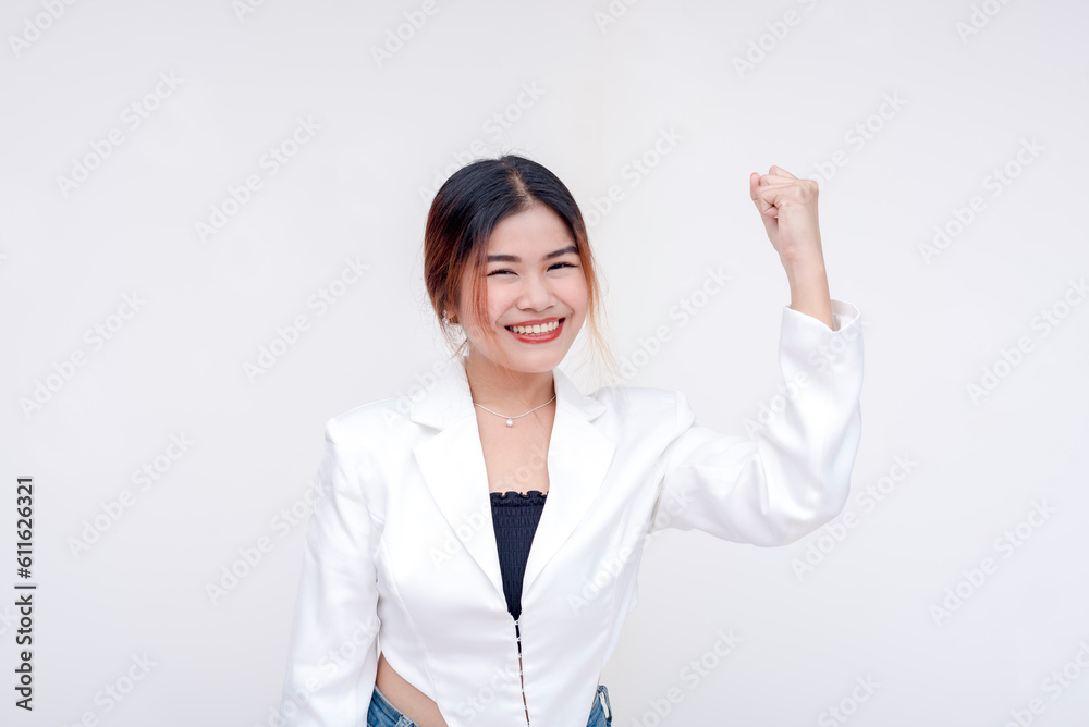 A cheerful young woman with her right arm raising up showing power and strength. Isolated in a white background. A cheerful young woman with her right arm raising up showing power and strength. Isolated in a white background.