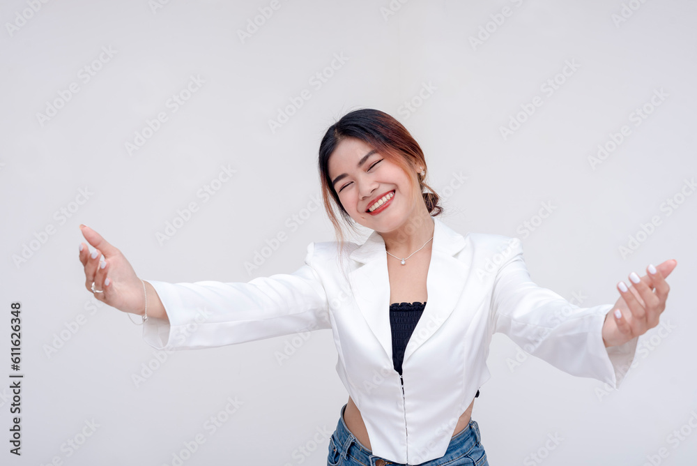 A welcoming and friendly young woman holding her arms open with eyes closed. Isolated on a white background. A welcoming and friendly young woman holding her arms open with eyes closed. Isolated on a white background.