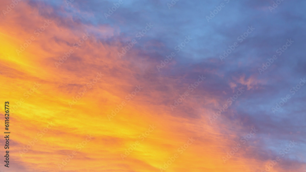 Dramatic cumulus clouds on sunny day at sunset painted with sun. Atmosphere multicolor background or wallpaper