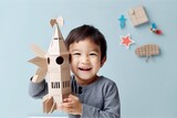 A boy is holding a cardboard rocket that Generative AI
