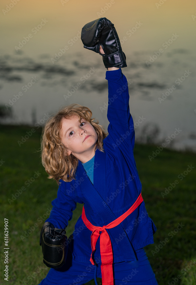 Kid boy practicing karate outdoor. Sport karate kids. Little boy