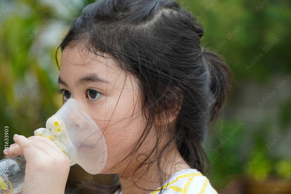 Cute asian girl with asthma using inhaler and spacer,Respiratory system and allergies Cute asian girl with asthma using inhaler and spacer,Respiratory system and allergies