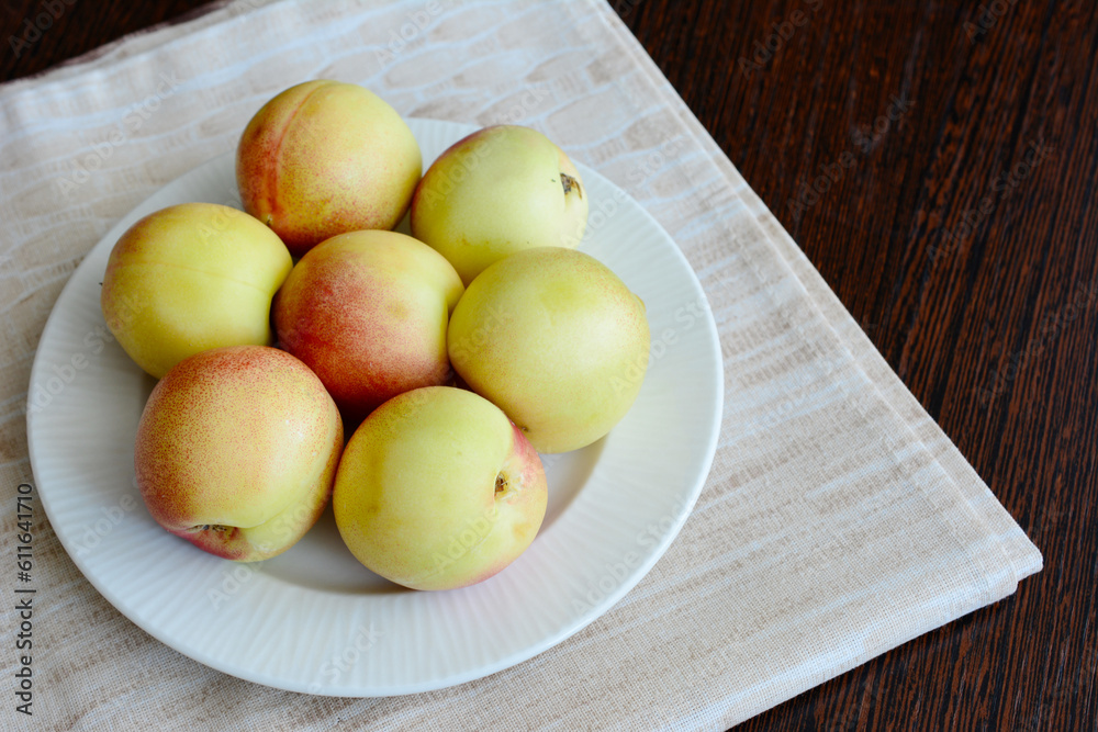 yellow nectarines on white plate on the kitchen table, copy space yellow nectarines on white plate on the kitchen table, copy space