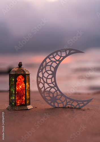 Photography Eid Mubarak background, half moon shape with colourful lantern lamp in the beach