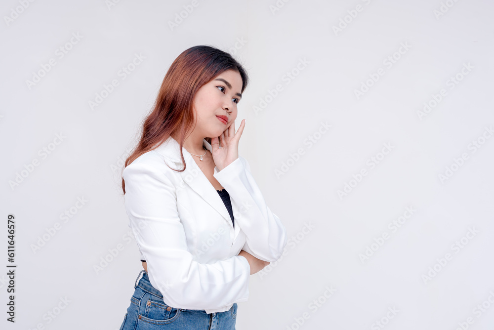 A problematic young woman with one hand to her cheek and head tilted in deep thought while facing the right side. Isolated on a white background. A problematic young woman with one hand to her cheek and head tilted in deep thought while facing the right side. Isolated on a white background.