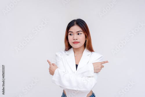 Φωτογραφία An unsure young woman looking down with her arms crossed while fingers pointing towards opposite direction