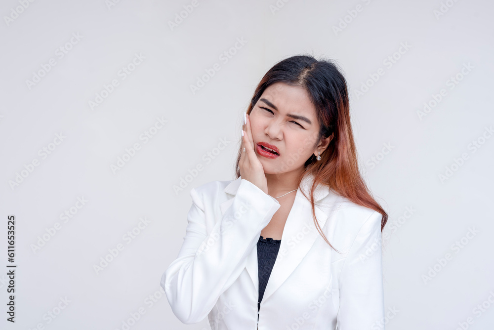 A distressed young woman with severe toothache holding her cheek in agony. Isolated on a white background. A distressed young woman with severe toothache holding her cheek in agony. Isolated on a white background.