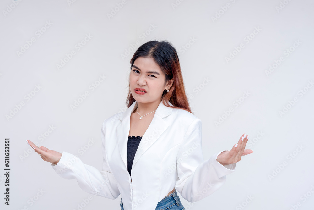 An irritated young woman raising her hands and shrugging in disinterest. Isolated on a white background.