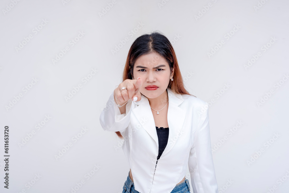 An irked and irritable young woman glaring and pointing at the camera. Isolated on a white background. An irked and irritable young woman glaring and pointing at the camera. Isolated on a white background.