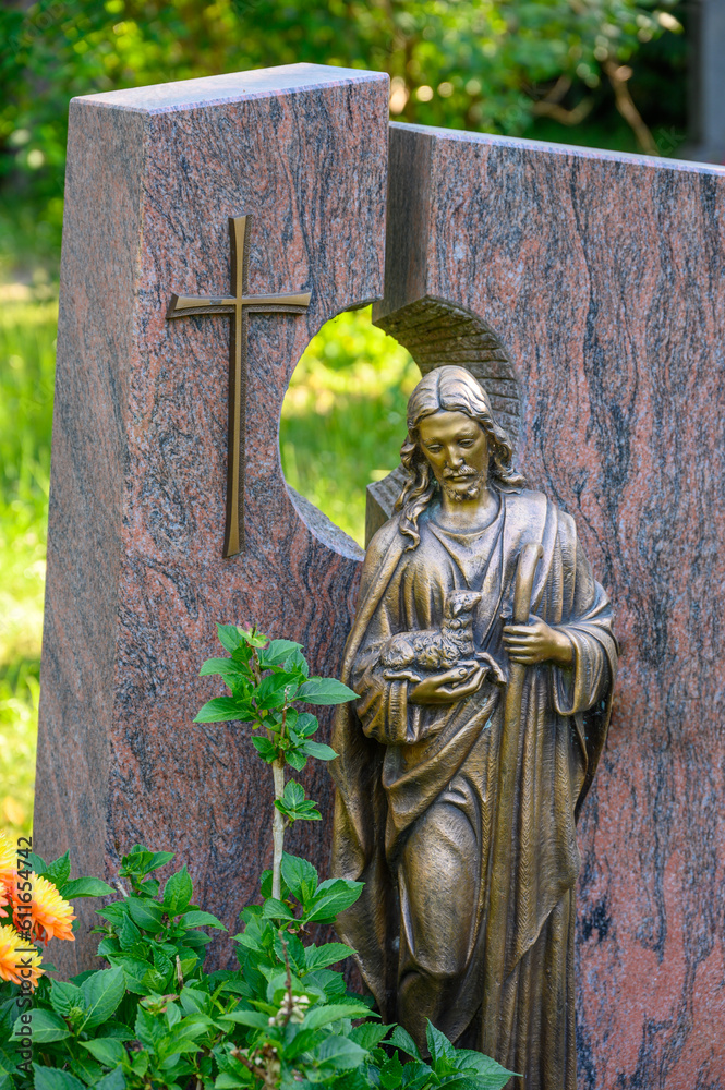 grabstein-mit-kreuz-und-figur-der-gute-hirte-friedhof-stock-photo