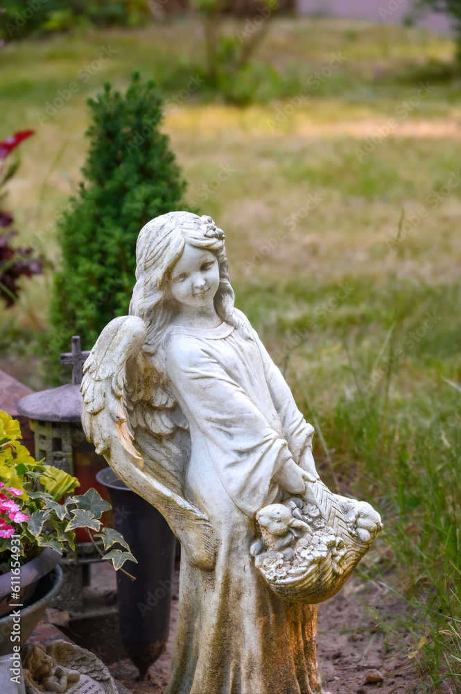 Kindlicher Engel mit Korb an Grabstätte