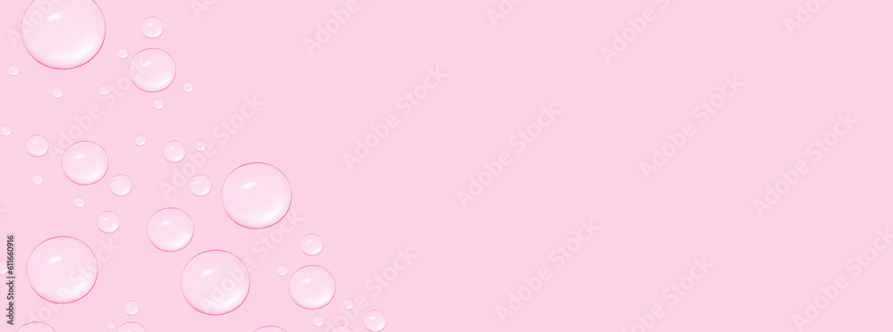 Drops of transparent gel or water in different sizes. On a pink background.