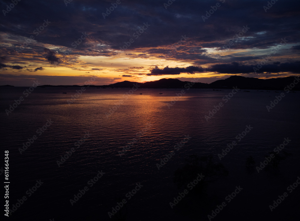 Dramatic aerial landscape with sunset on the sea shore. Beautiful cloudy sky.