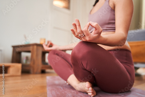 Cropped view of gracious young woman doing meditation in lotus position while connecting fingers