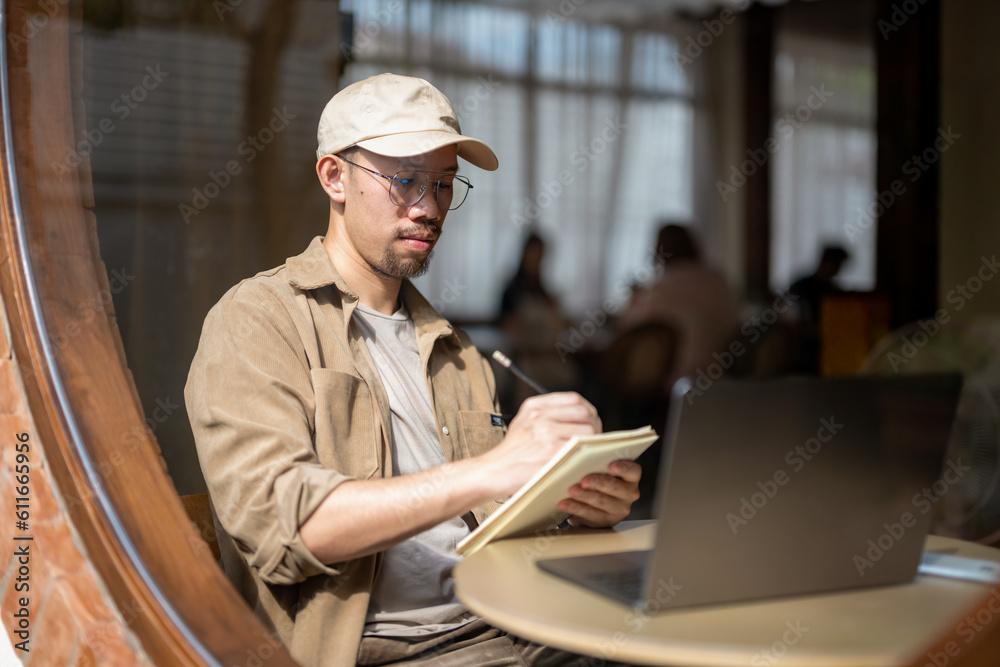 Freelance businessman sitting in front of her considering work at cafe, thinking new project work plan. Write a plan on a notebook. Freelance businessman sitting in front of her considering work at cafe, thinking new project work plan. Write a plan on a notebook.
