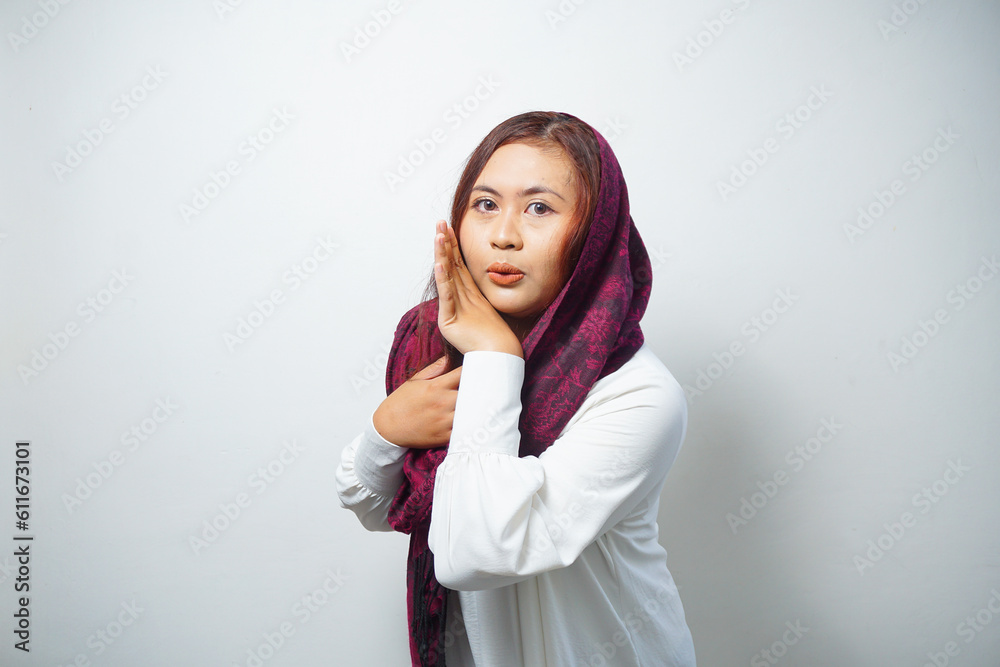 Young beautiful Asian Muslim woman wearing a hijab shouting and screaming loud with a hand on her mouth. communication concept. Young beautiful Asian Muslim woman wearing a hijab shouting and screaming loud with a hand on her mouth. communication concept.