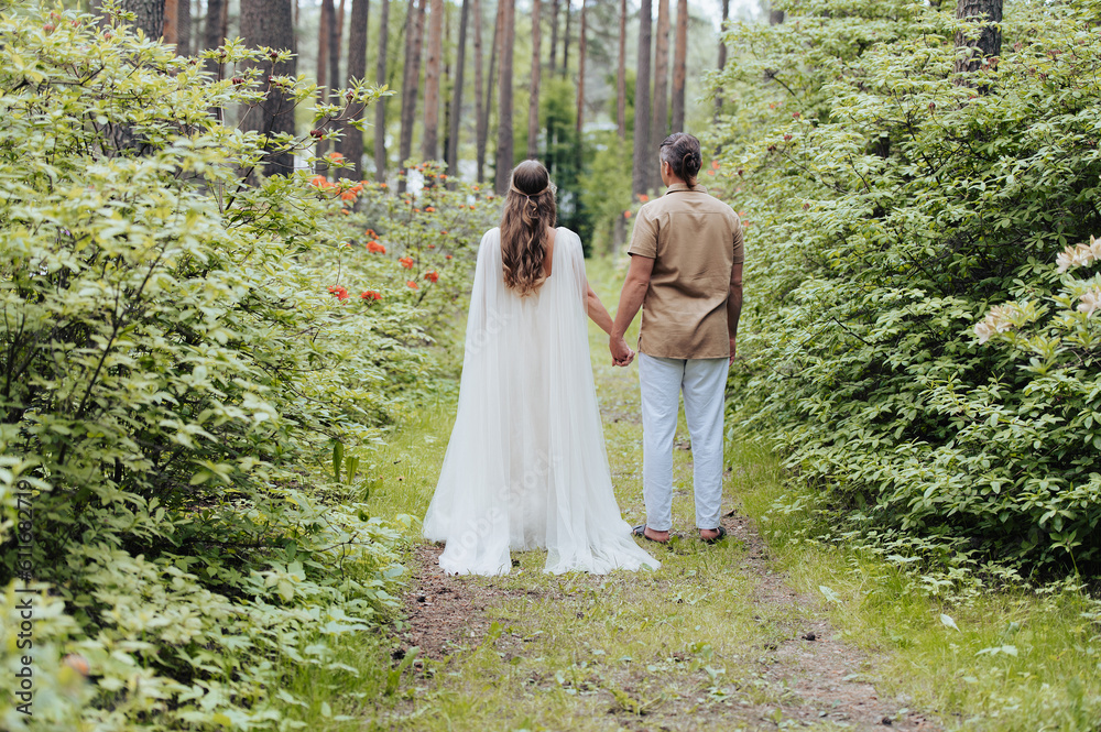 Rear view on beautiful bride and groom in green nature. Rear view on beautiful bride and groom in green nature.