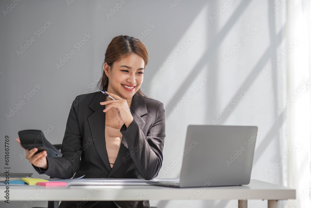 Business woman using calculator for do math finance on wooden desk in office and business working background, tax, accounting, statistics and analytic research concept. Business woman using calculator for do math finance on wooden desk in office and business working background, tax, accounting, statistics and analytic research concept.