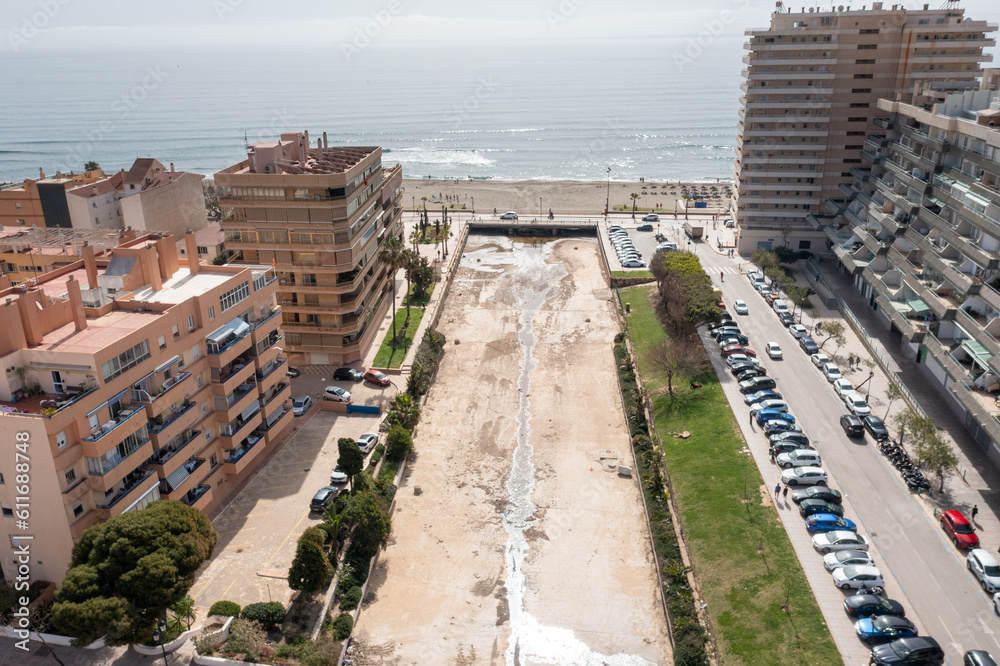 Aerial drone photo of the beautiful beach front of the coastal town of Fuengirola in Malaga Spain Costa Del Sol, showing the storm drain that goes into the sea